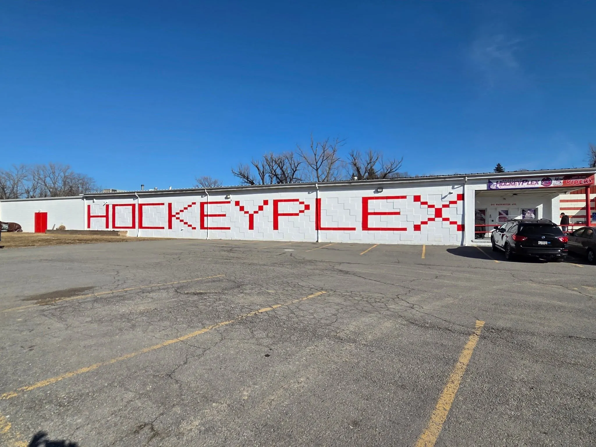The Bridgeville HockeyPlex from the parking lot, with HOCKEYPLEX painted across the white block wall