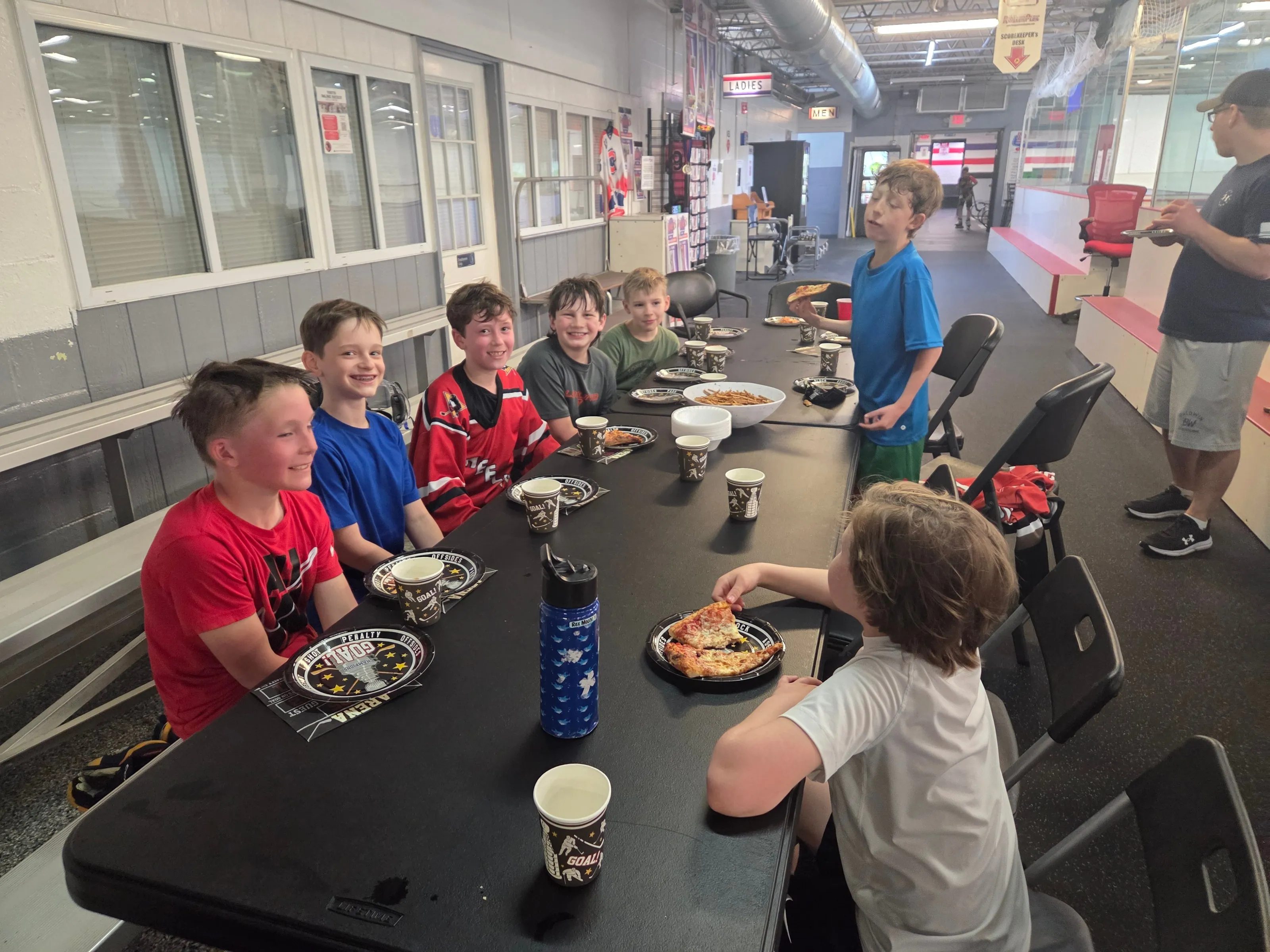 Kids eating pizza at party tables in the Main Hall at the Bridgeville HockeyPlex